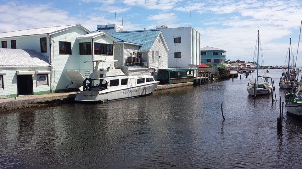 A Caye Caulker water taxi tied up on the creek in Belize City, next to wooden buildings